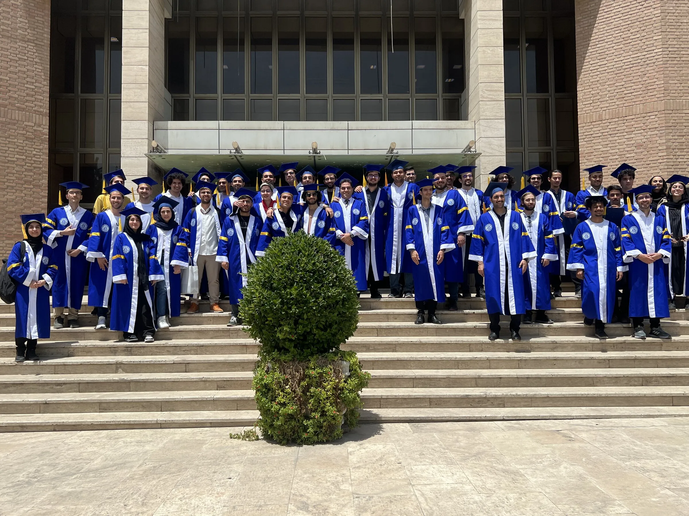 Graduates of the Department of Computer Engineering, Sharif University of Technology, in caps and gowns on the steps of the university